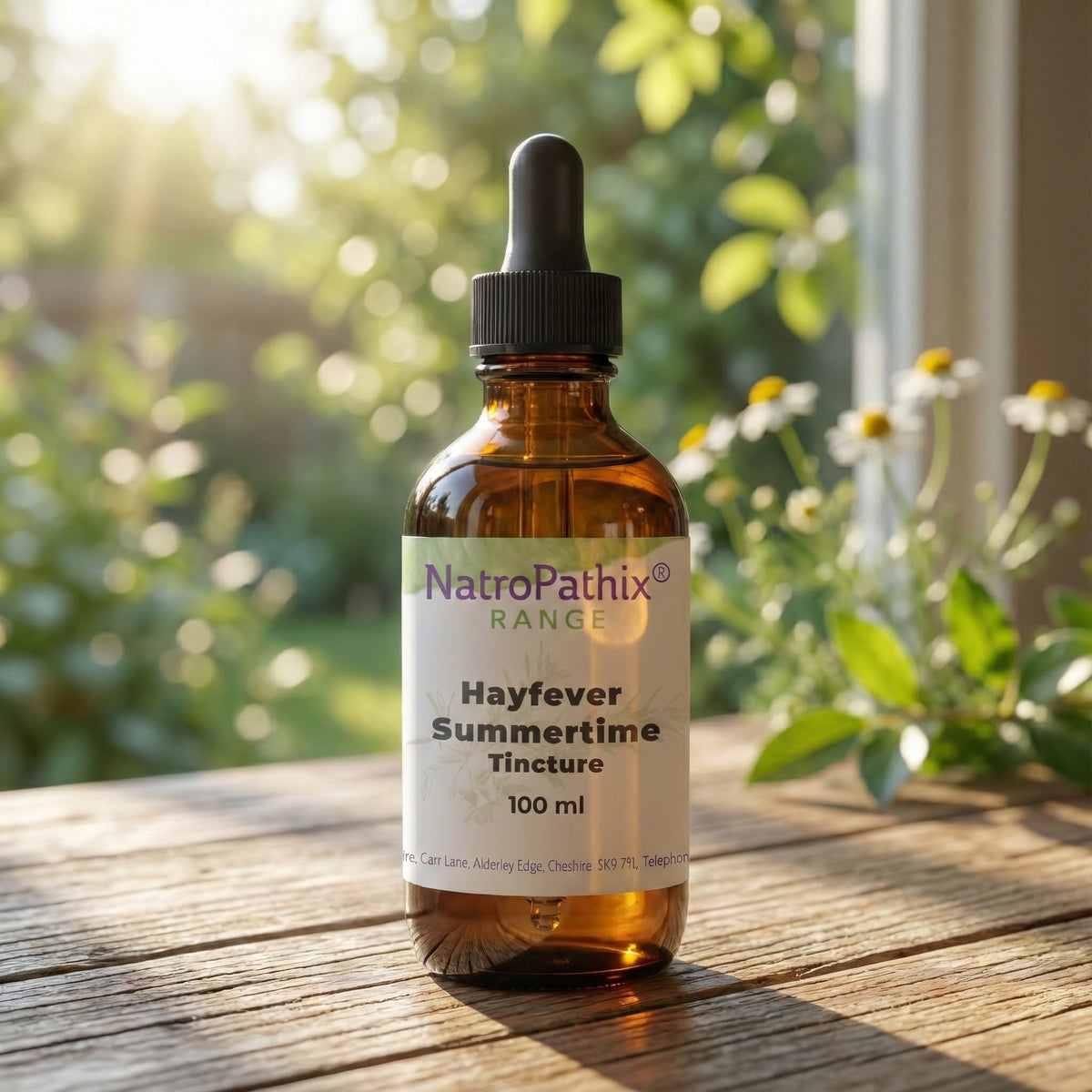 A 50ml brown glass dropper bottle labeled "Summertime Tincture," valued for its natural antihistamine benefits, rests on a sunlit wooden table.