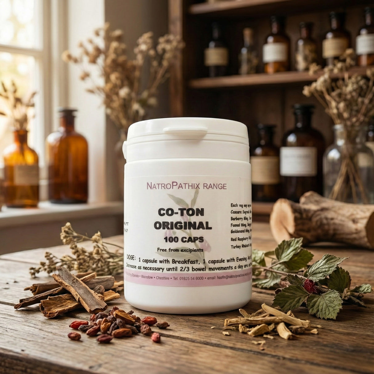 A bottle of Co-Ton Original - 100 Caps rests on a rustic table with dried herbs and glass bottles, emphasizing its herbal formula crafted to help reduce bloating.