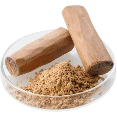 Two sandalwood sticks and sandalwood powder on a clear glass dish against a white background.
