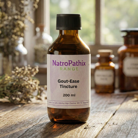 A brown glass bottle labeled "Gout-Ease Tincture - 200ml" sits on a wooden table, designed to help reduce uric acid and promote natural gout relief.