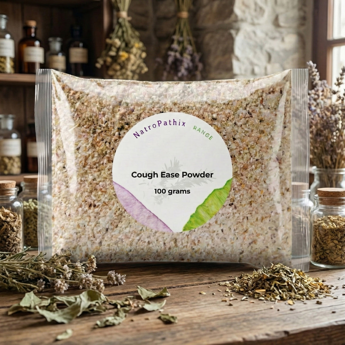 A bag labeled "Cough-Ease Powder - 100g" rests on a table with dried herbs and glass jars, showcasing this herbal remedy designed to provide effective relief from dry cough.