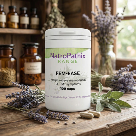 A bottle of Fem-Ease - 100 Capsules rests on a wooden table with herbs and dried flowers, offering natural support for menopause symptoms.