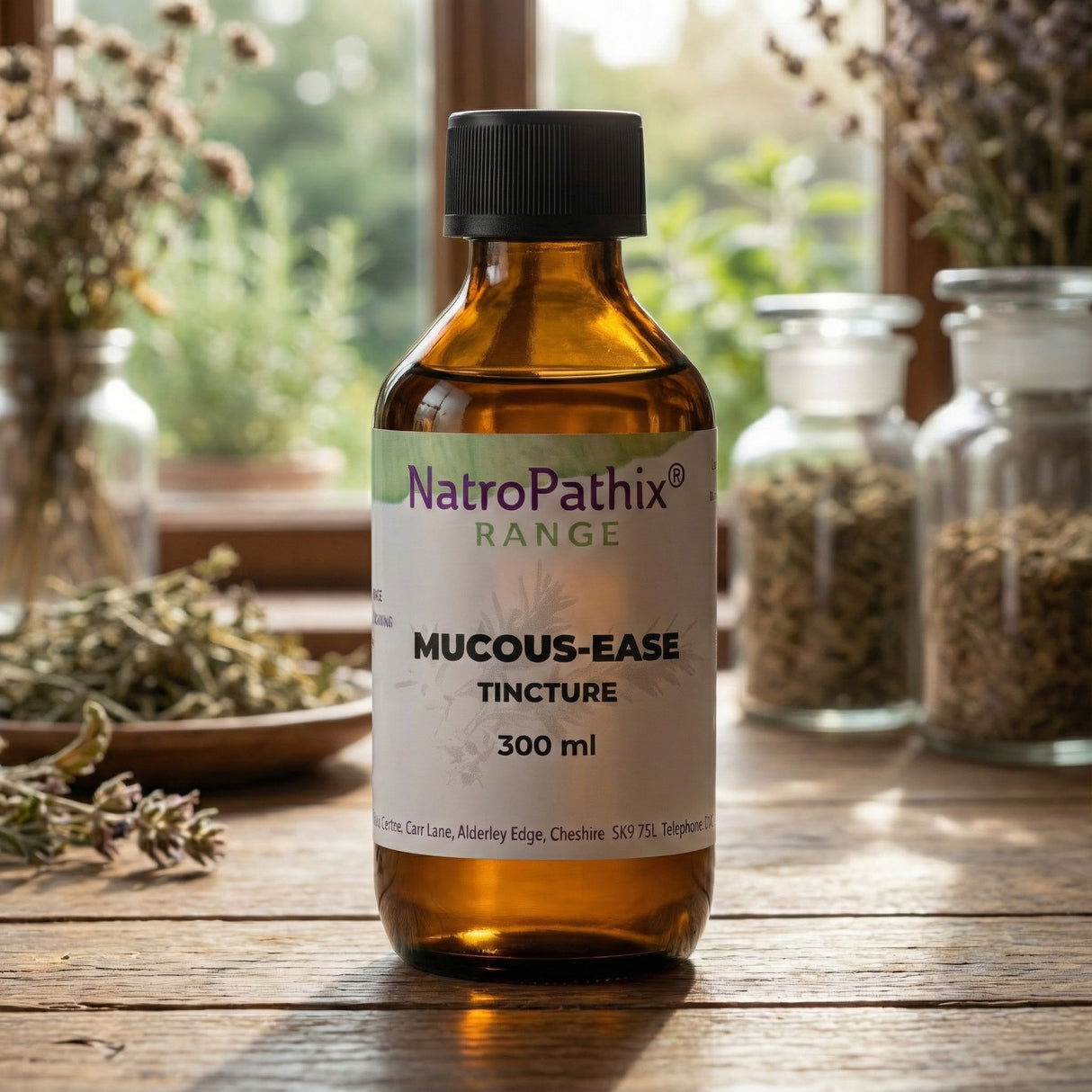 A brown bottle labeled "Mucous-Ease Tincture - 200/300ml" sits on a wooden table with herbs, an herbal tincture designed to help ease congestion and naturally support clear airways.