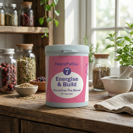 A bottle of Energise & Build - 60 caps on a wooden kitchen counter with seeds and jars, formulated to support healthy circulation and energy levels.