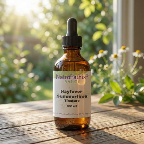A 50ml brown glass dropper bottle labeled "Summertime Tincture," valued for its natural antihistamine benefits, rests on a sunlit wooden table.