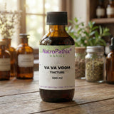 A bottle of Va Va Voom Tincture (100/200/300ml) sits on a wooden table with herbs behind it, showcasing its adaptogenic properties and natural energy-boosting benefits.